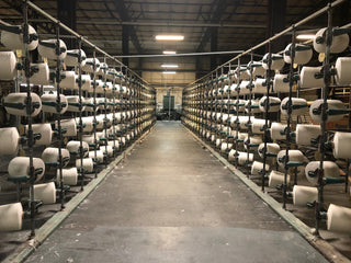 An American textile factory in action, with workers inspecting and producing high-quality textiles, representing the latest updates on the industry’s growth and sustainability.