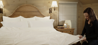 A well-made bed featuring a soft cotton duvet cover in a neutral shade, demonstrating the simplicity and elegance of using quality bedding.