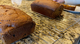 Freshly baked pumpkin bread on a rustic table, with Red Land Cotton towels nearby, representing a cherished holiday tradition.
