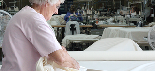 Skilled women sewing Red Land Cotton bedding by hand in a workshop, highlighting the craftsmanship and attention to detail behind each product.